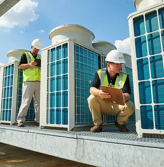 Two utility workers wearing hardhats and vest